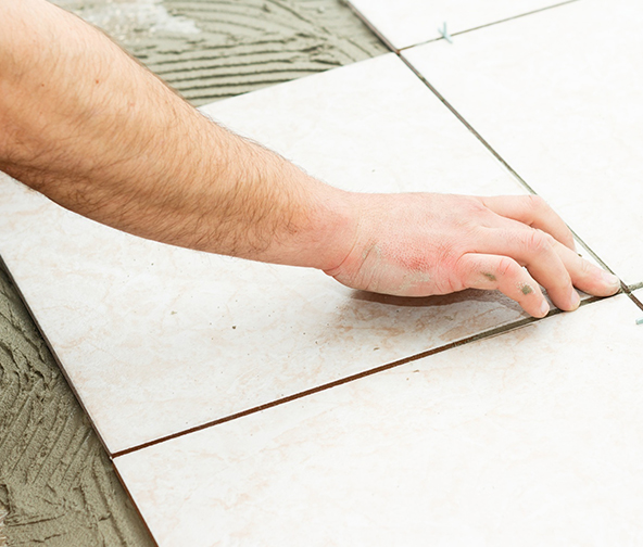 Professional installer placing down a fresh tile