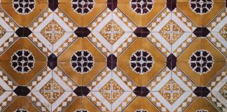 Photo of an individuals feet standing atop ornate tile flooring