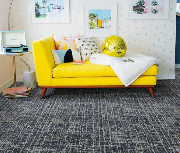 Patterned carpet under a bright yellow lounge chair