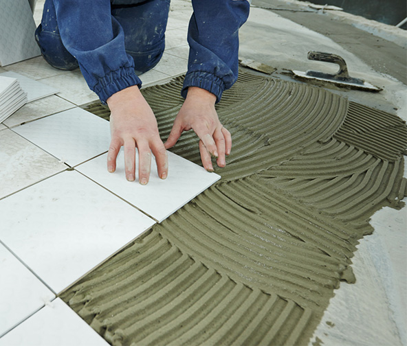 Professional installer carefully placing down a floor tile